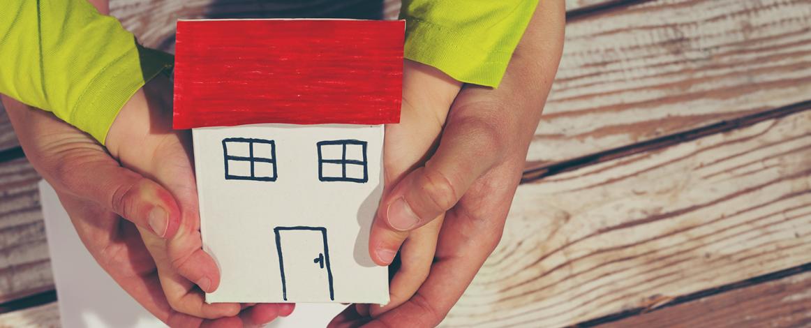 hands holding a paper house